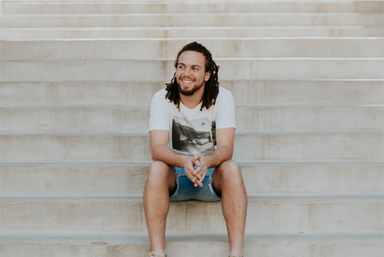 A man sitting on concrete steps smiling
