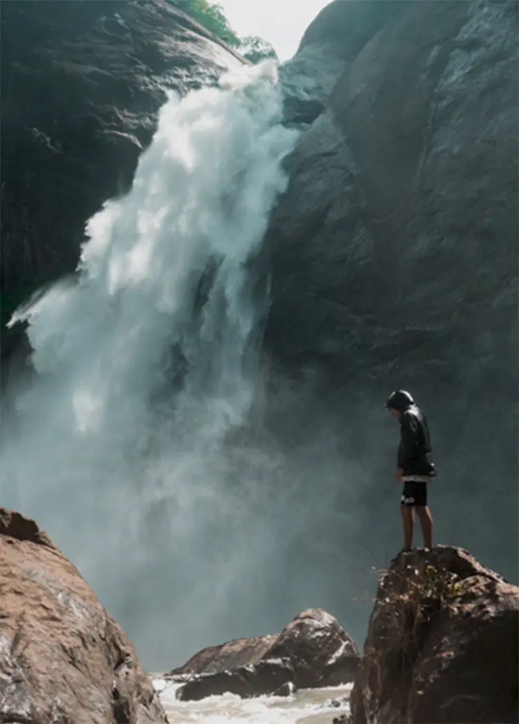 A man in front of a waterfall