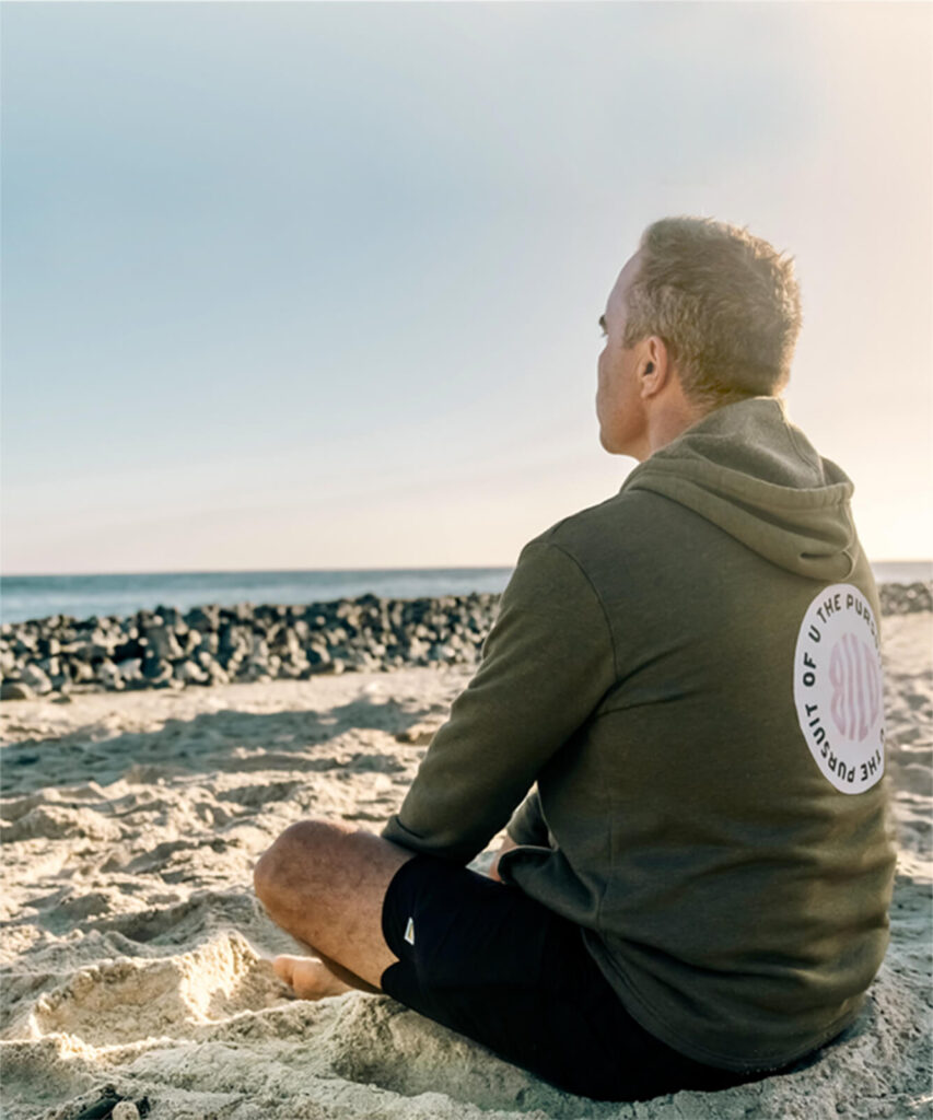 man meditating on beach